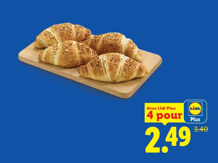 Quatre croissants aux amandes sur une planche en bois, avec une offre promotionnelle.
