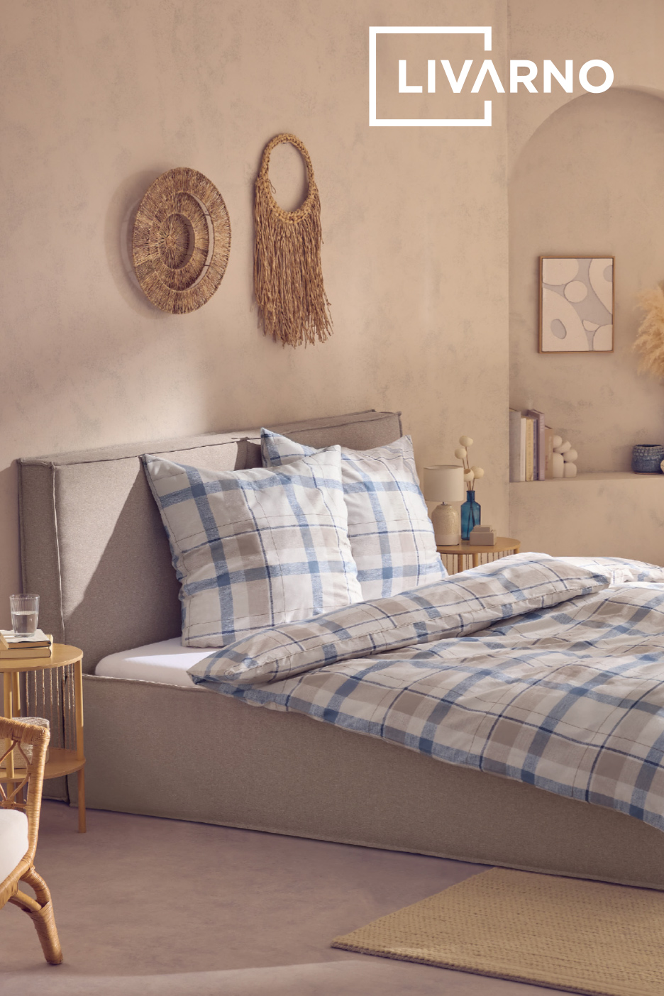 Chambre à coucher avec lit gris, parure de lit à carreaux bleus et décorations murales en paille.