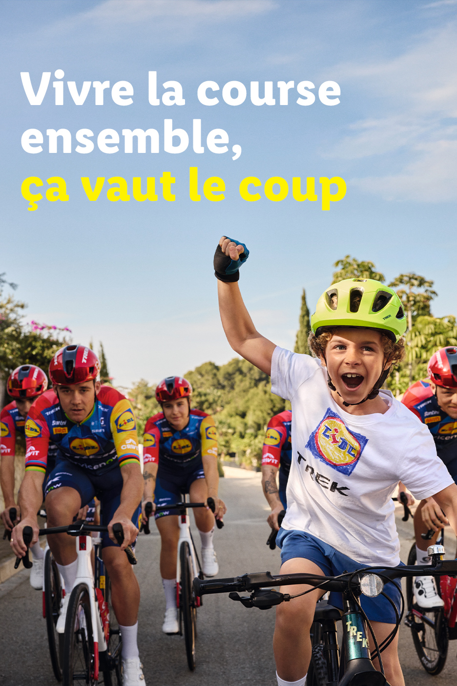 Un enfant souriant sur un vélo avec des cyclistes adultes, texte : Vivre la course ensemble, ça vaut le coup.
