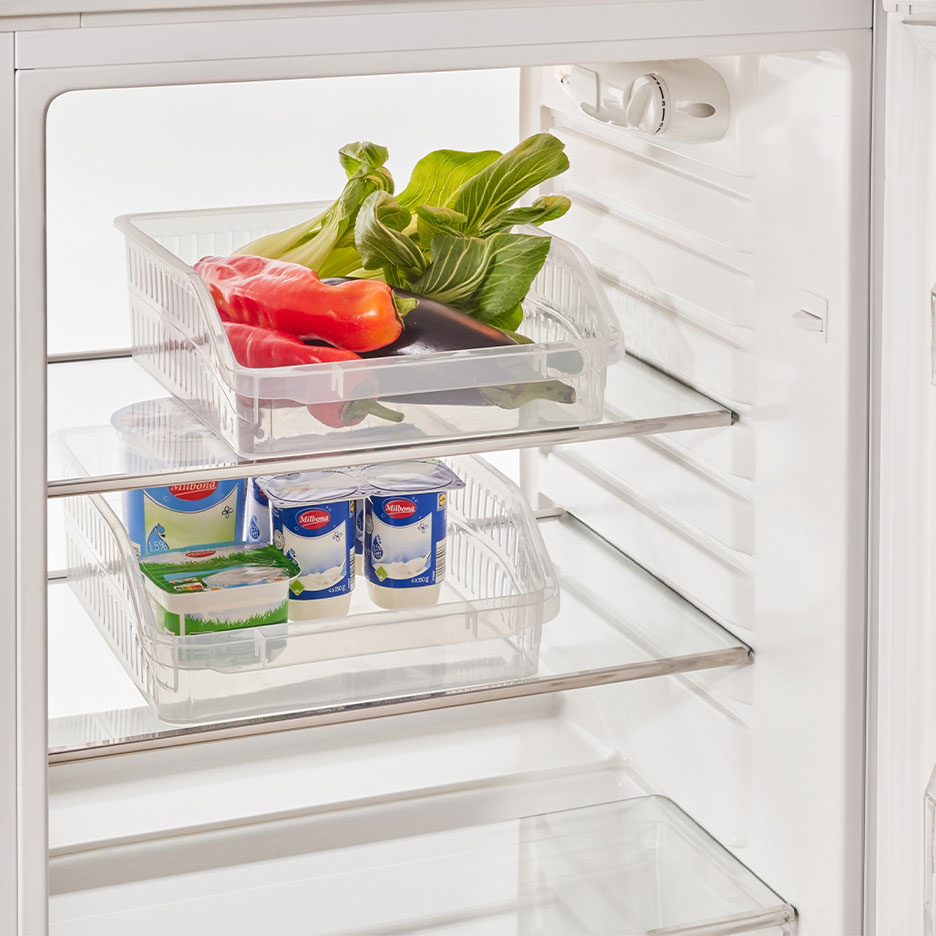 Réfrigérateur avec organisateurs transparents remplis de légumes, yaourts et fromage.